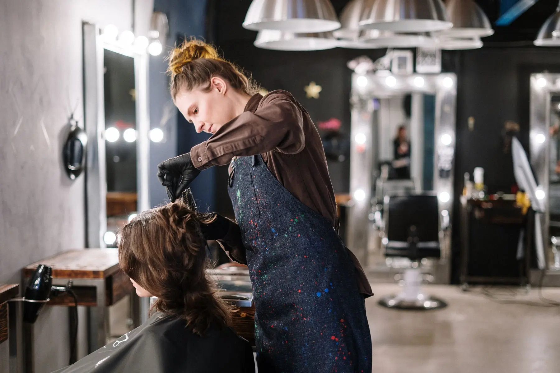 Stylist applying color to a client's hair in a professional salon