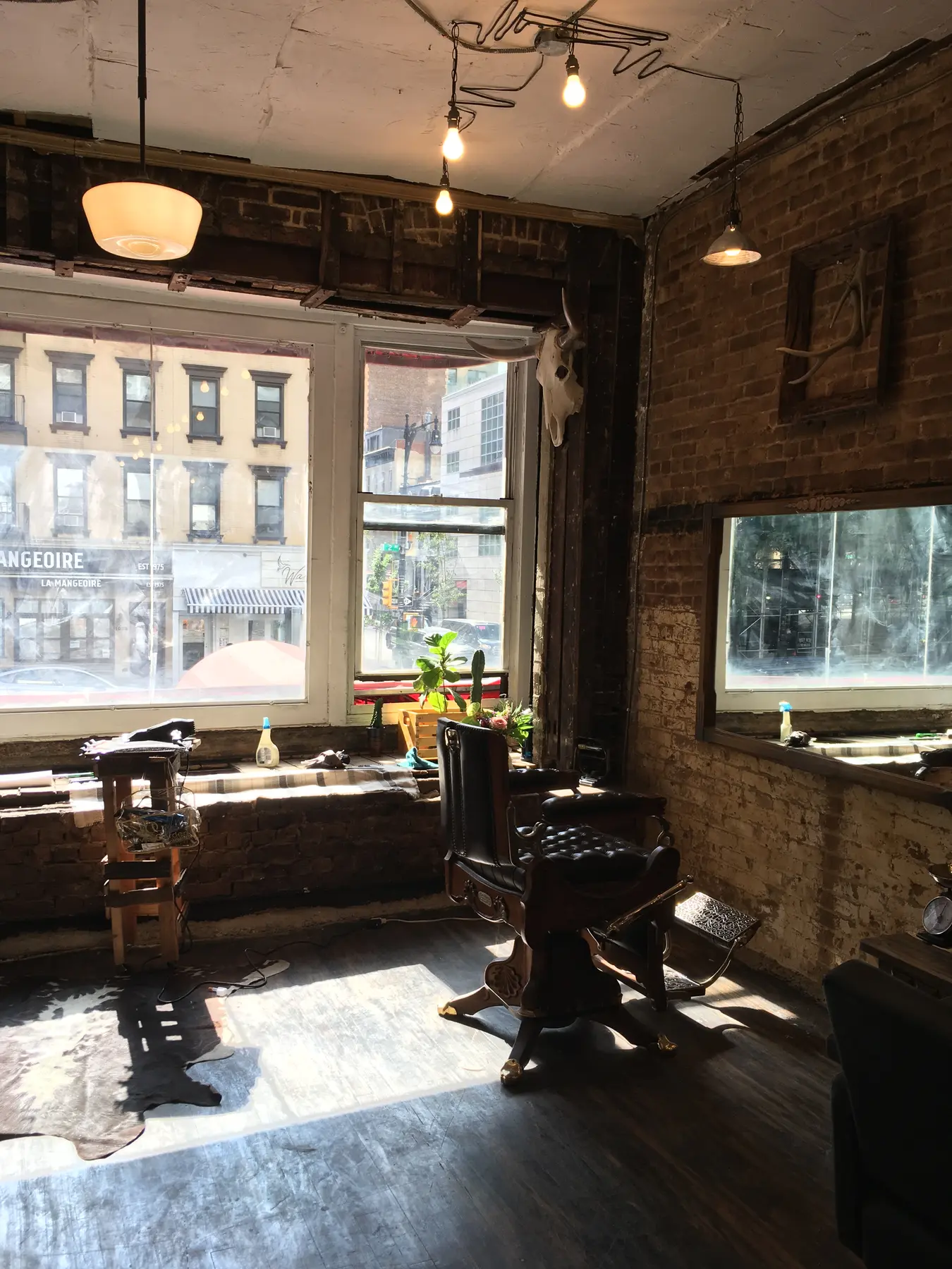 Sunlit interior of Kuniya Hair with exposed brick and a vintage salon chair